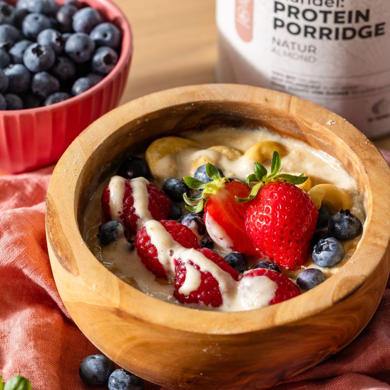 Serviervorschlag für JOY NATURALS Mandel Protein Porridge Natur mit Früchten und Mandelmus.